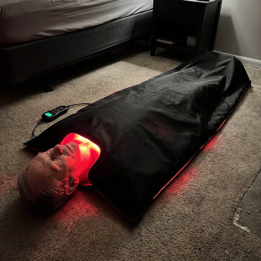 Man lying inside the Optimal Red Light Bag with the top panel folded over